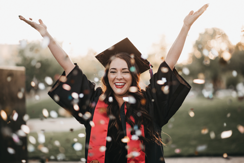 college graduate throwing confetti in the air